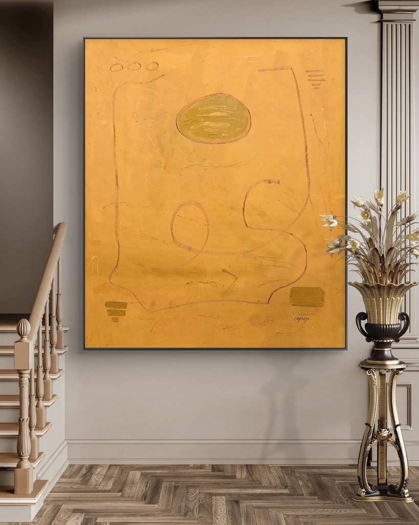 Quadro astratto ocra di Cardusu allestito in un ingresso elegante vicino a una scala e parquet in legno